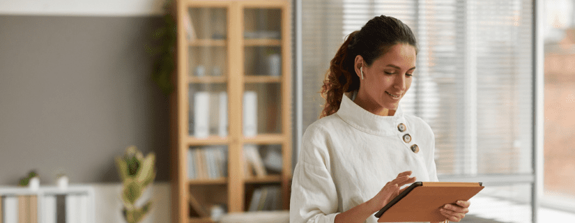 A woman business owner looking at an ipad in her office.