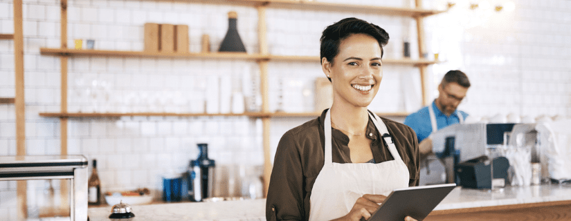 Small business owner smiling with an ipad.