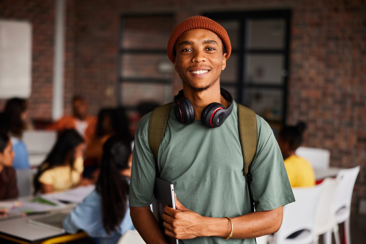 Smiling-young-male-college-student-wearing-headphones